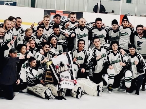 A group of hockey players posing for a picture with their trophy.